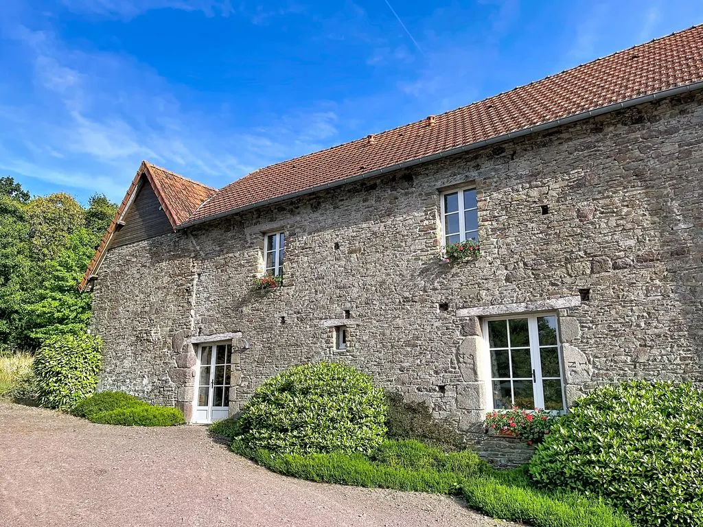 Façade en pierre du gîte sous le ciel bleu